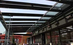 Voici une terrasse couverte avec un toit en verre et en métal