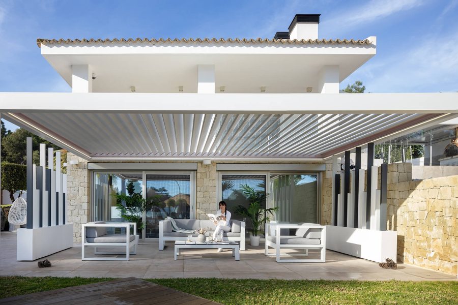 Il s'agit d'une terrasse moderne et élégante, partiellement couverte par une pergola
